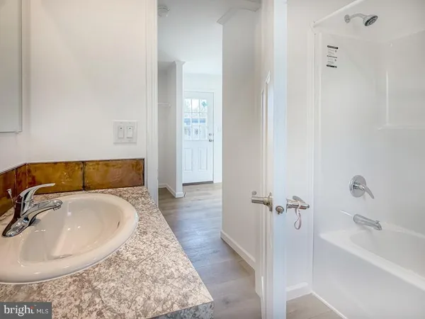 a bathroom with a tub sink and mirror