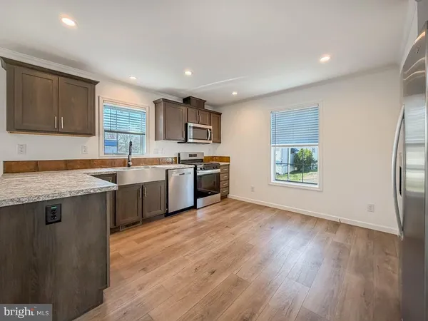 a kitchen with stainless steel appliances granite countertop a sink a stove top oven a counter space and cabinets
