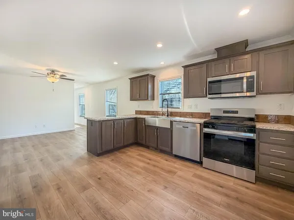 a kitchen with stainless steel appliances a stove top oven a sink and a microwave