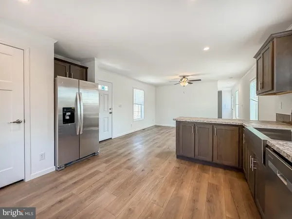 a kitchen with stainless steel appliances granite countertop a refrigerator and a stove top oven