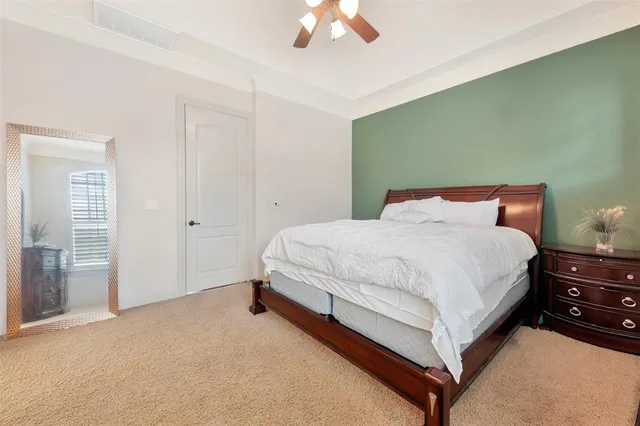a spacious bedroom with a bed and a chandelier