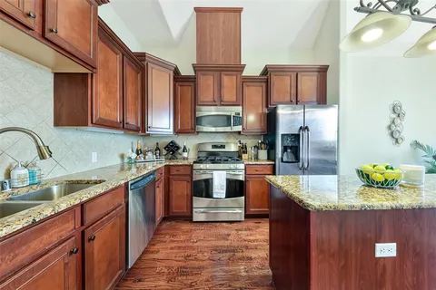 a kitchen with stainless steel appliances granite countertop a sink and a stove