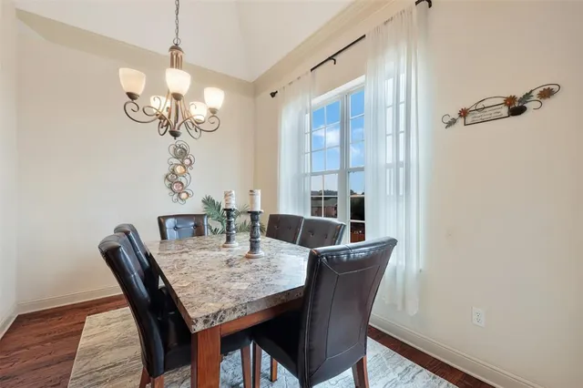 a view of a dining room with furniture wooden floor and chandelier