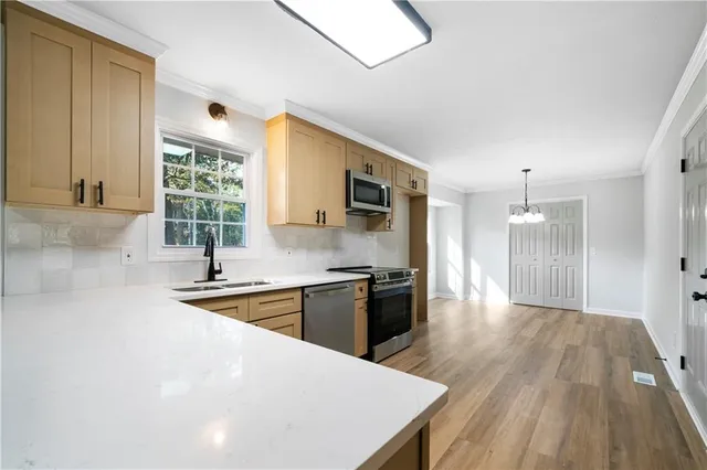 a kitchen with stainless steel appliances a stove top oven a sink and a refrigerator