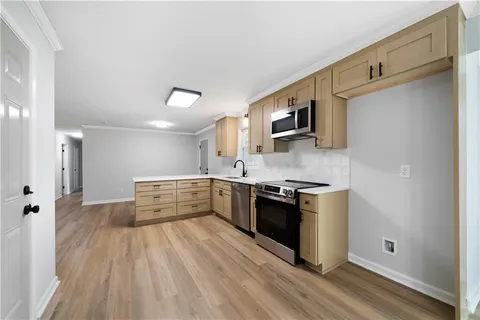 a room with kitchen island a sink and a refrigerator