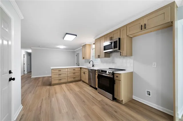 a room with kitchen island a sink and a refrigerator