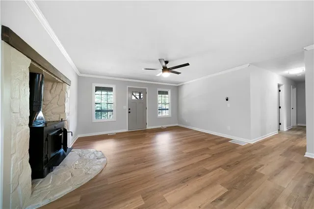 a kitchen with stainless steel appliances granite countertop a sink dishwasher a stove and a refrigerator with wooden floor