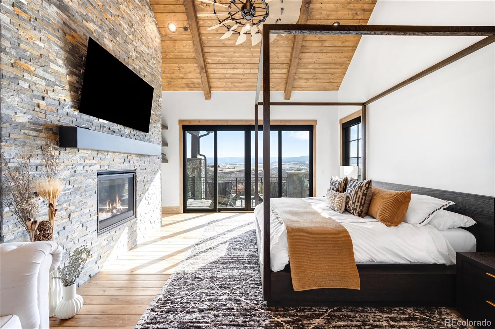 3148 Keep Drive Sedalia, CO 80135 - Photo 12 of 44 a bedroom with a bed a flat screen tv and a fireplace