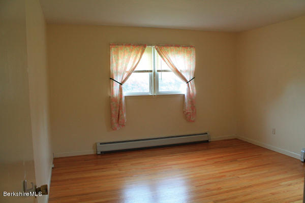 265 Yokun Road Richmond, MA 01201 - Photo 15 of 24 an empty room with wooden floor and windows