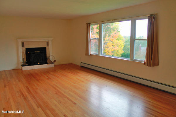 265 Yokun Road Richmond, MA 01201 - Photo 4 of 24 an empty room with wooden floor and windows