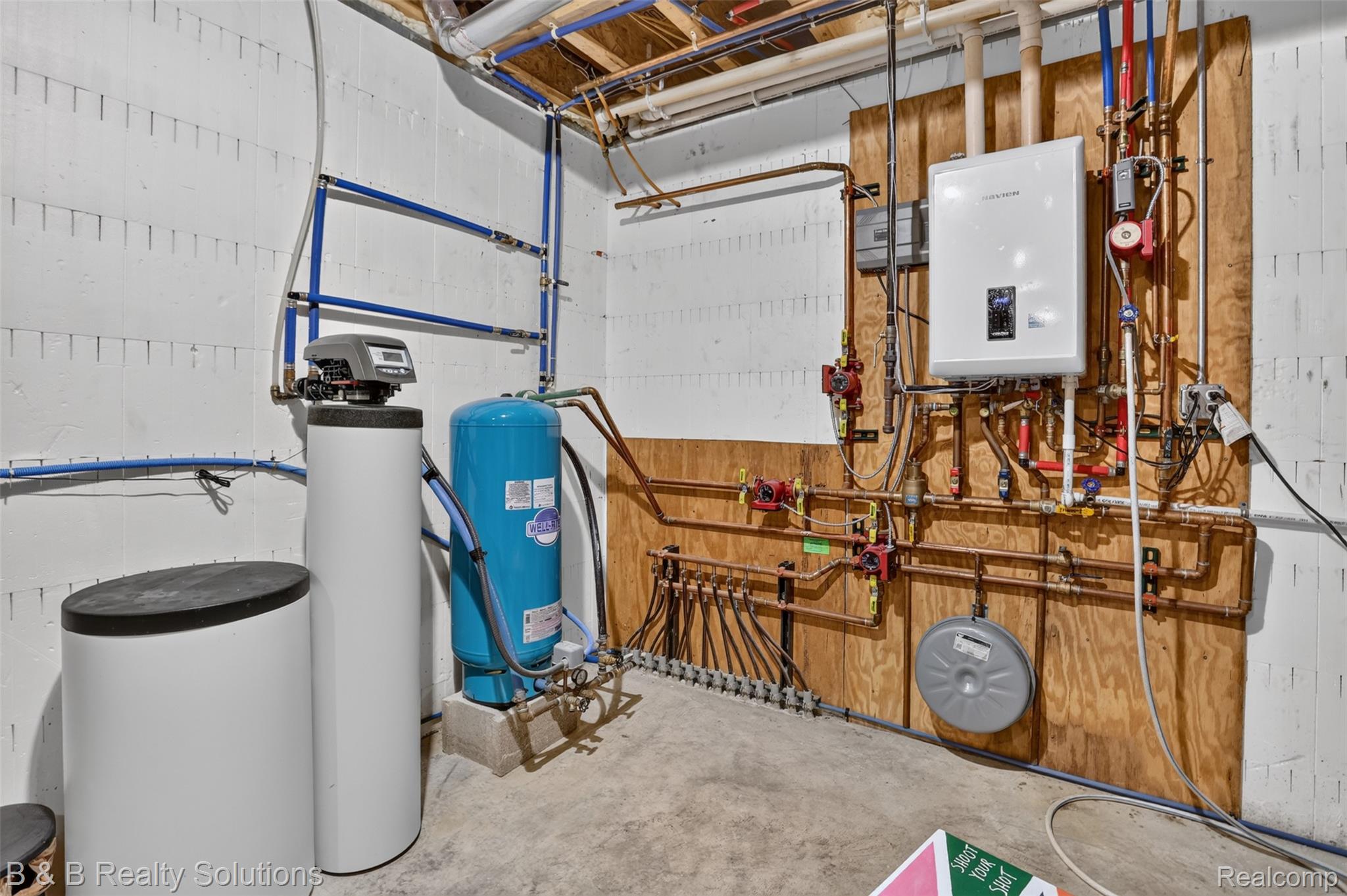 6204 Fish Lake Road North Branch, MI 48461 - Photo 48 of 79 Utility area featuring a tankless water heater, water softener system, water pressure tank, and extensive PEX and copper plumbing