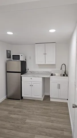 a kitchen with a refrigerator sink and cabinets