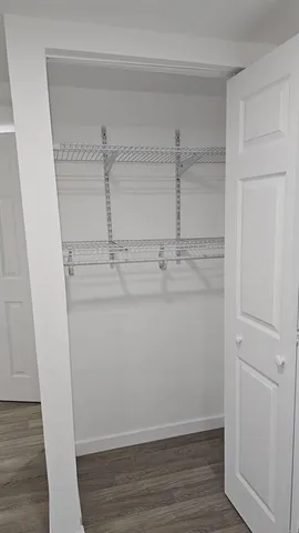 a view of storage and utility room with wooden floor