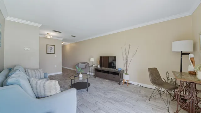 a kitchen with granite countertop cabinets a stove a microwave a dining table and chairs with wooden floor