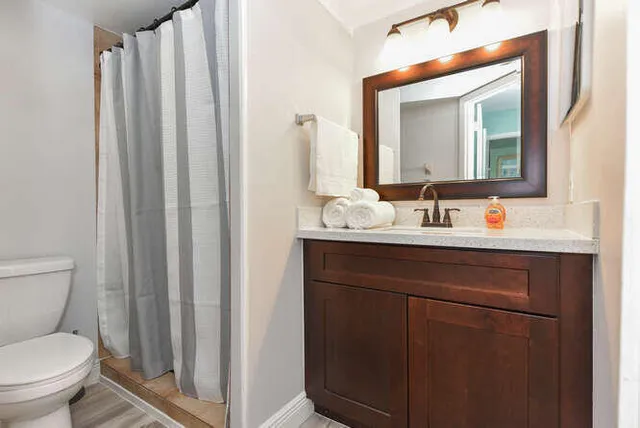 a bathroom with a toilet sink and mirror