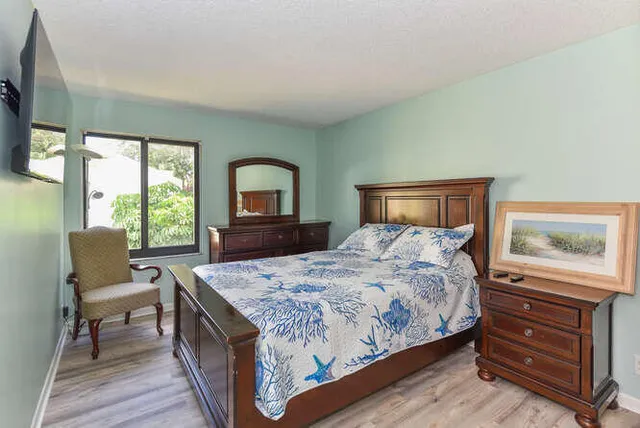 a bedroom with a bed and a dresser next to a window