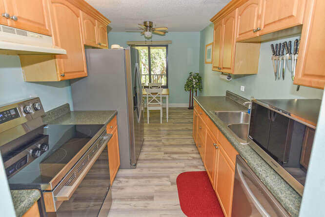 150 Pineview Road, Unit L6 Jupiter, FL 33469 - Photo 5 of 22 a kitchen with wooden cabinets and a sink