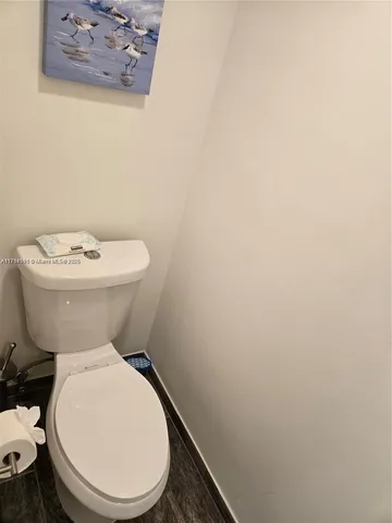 a white toilet sitting next to a white wall