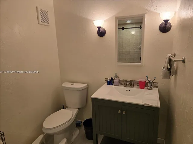 a bathroom with a sink mirror vanity and toilet