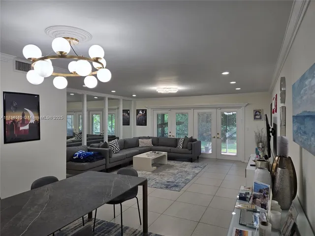 a living room with furniture a chandelier and a flat screen tv