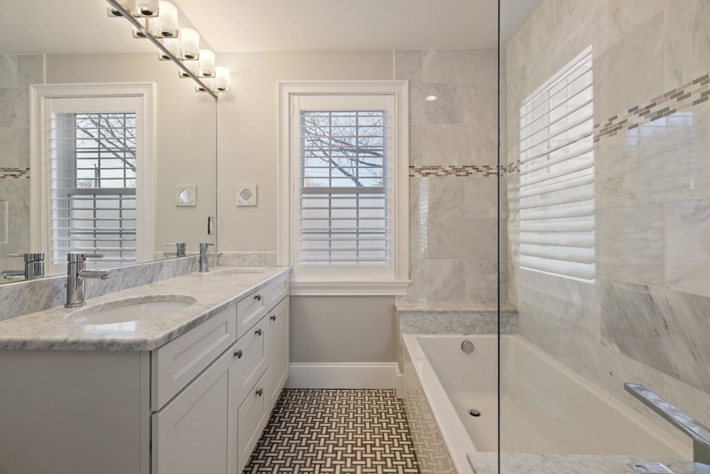 23 Thomas Road Wellesley, MA 02482 - Photo 15 of 23 a bathroom with a granite countertop sink a mirror a bathtub and next to a window