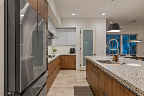 a large kitchen with stainless steel appliances granite countertop a sink and a refrigerator