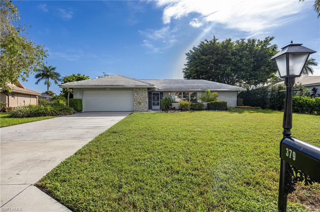 379 Torrey Pines Point Naples, FL 34113 - Photo 3 of 21 Ranch-style exterior with a stone façade accent, attached garage, and a concrete driveway