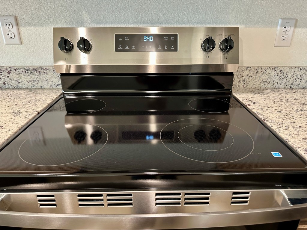 2913 Quail Rdg Lane, Unit B Temple, TX 76501 - Photo 11 of 20 Kitchen view of light stone countertops, electric stove, and a textured wall