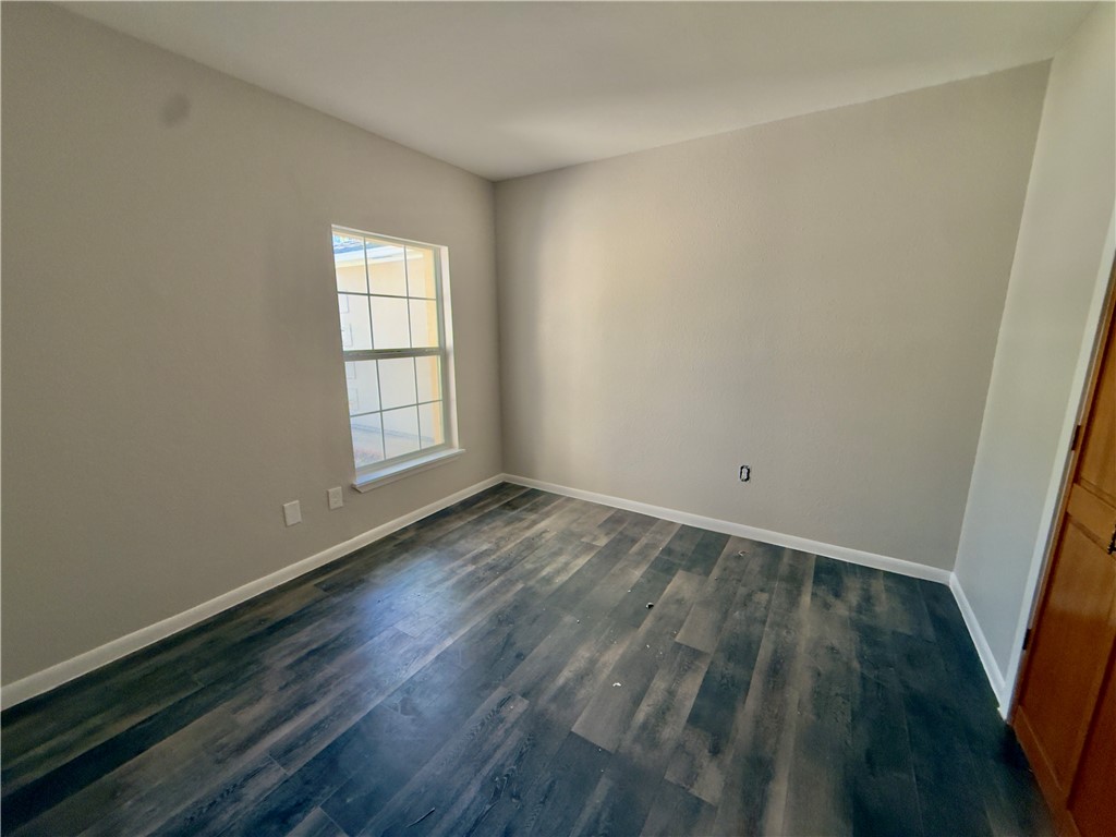 4006 Easy Street Corpus Christi, TX 78418 - Photo 5 of 8 an empty room with wooden floor and windows