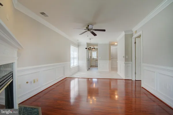 a view of a livingroom with wooden floor and a ceiling fan