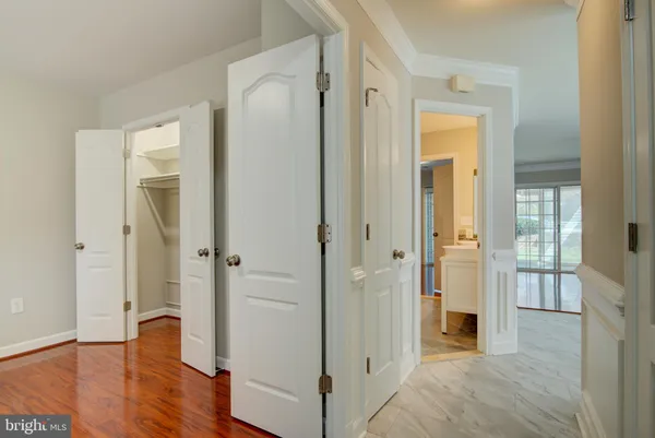 a view of a hallway with wooden floor and closet area