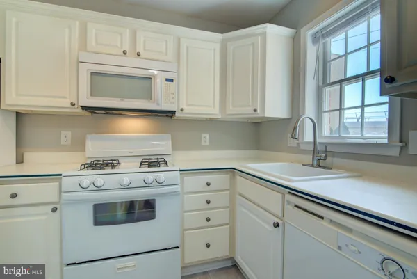 a kitchen with white cabinets and white appliances