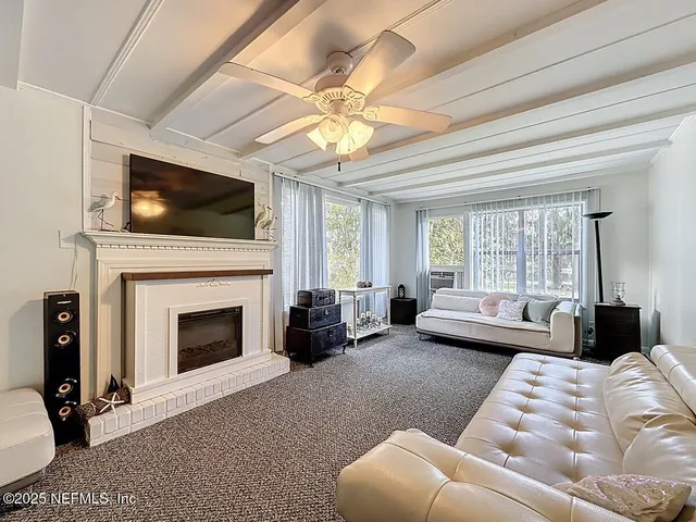 a living room with furniture fireplace and flat screen tv