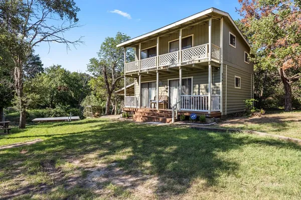 a view of a house with backyard and trees