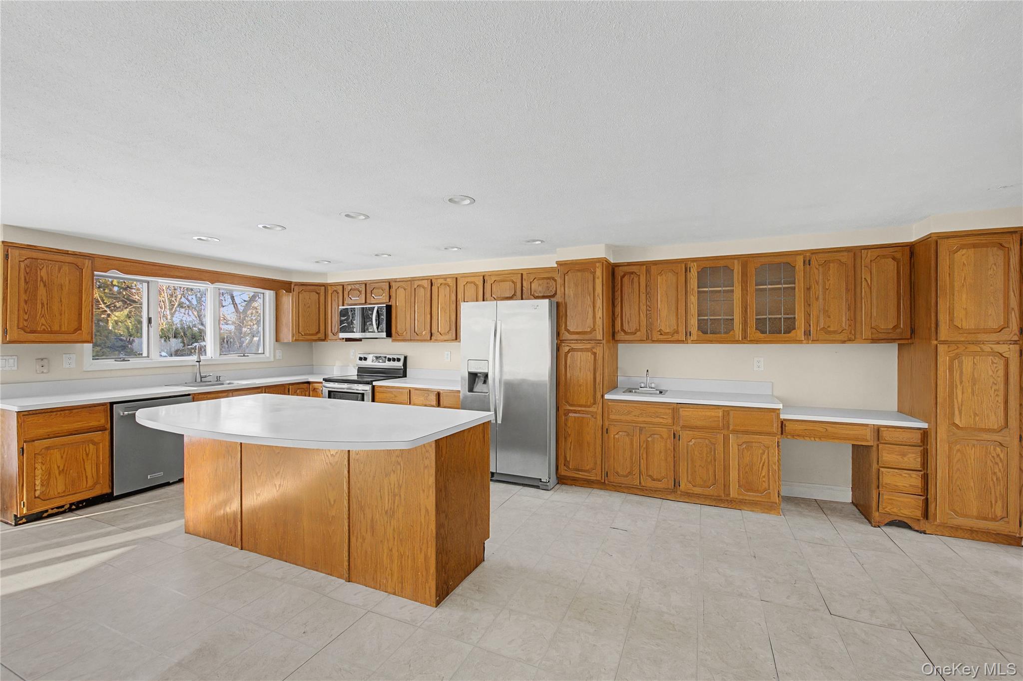 18 Woodbrook Drive Ridge, NY 11961 - Photo 13 of 33 a large kitchen with stainless steel appliances a stove a sink dishwasher and cabinets