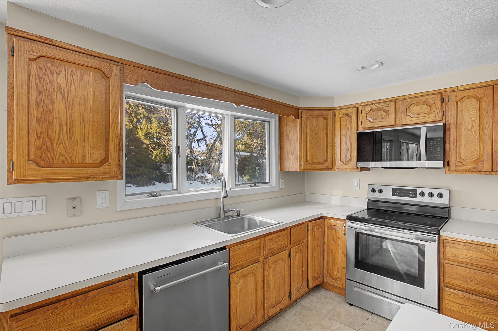 18 Woodbrook Drive Ridge, NY 11961 - Photo 16 of 33 a kitchen with stainless steel appliances a sink stove and microwave