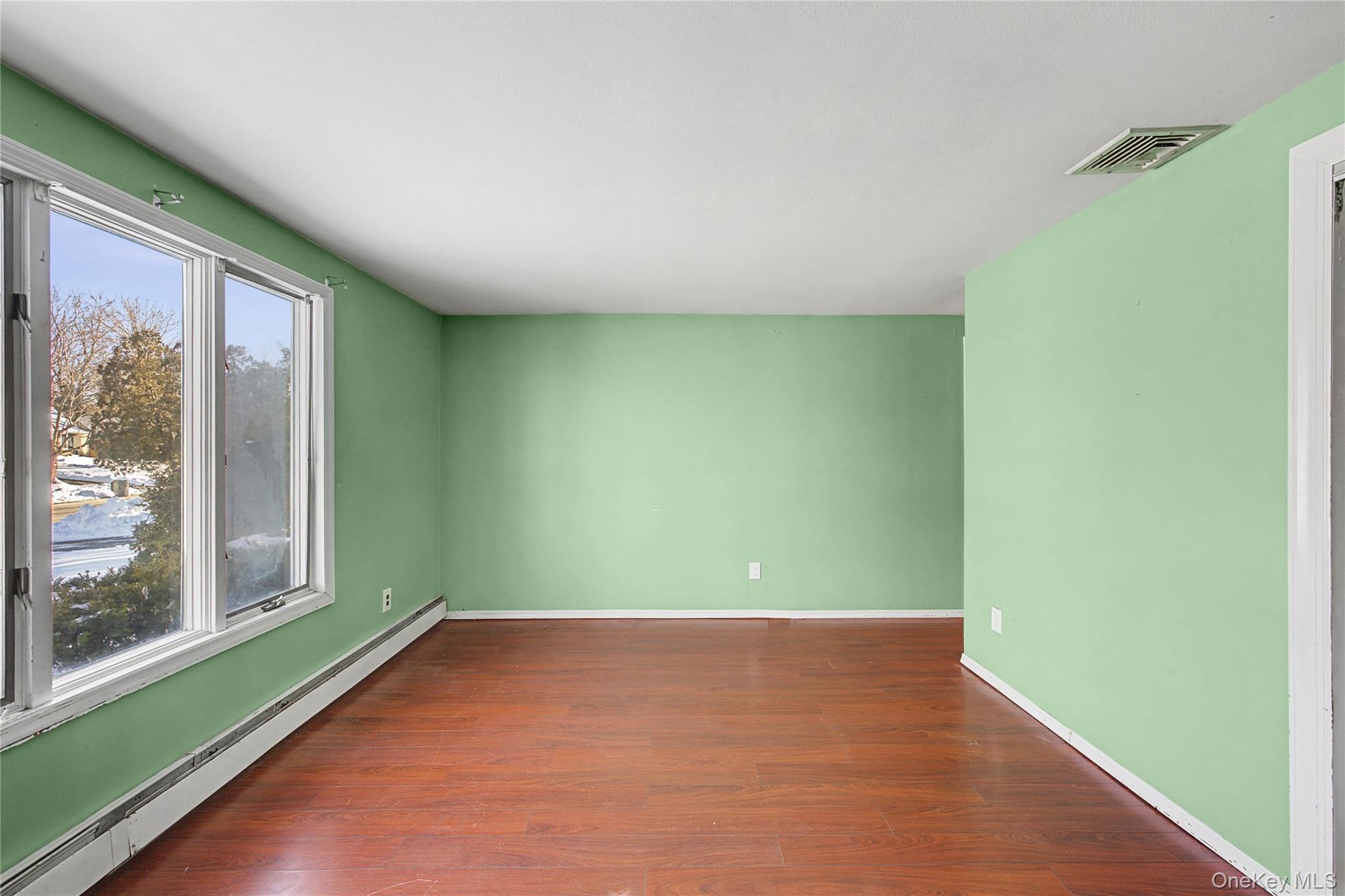 18 Woodbrook Drive Ridge, NY 11961 - Photo 29 of 33 an empty room with wooden floor and windows
