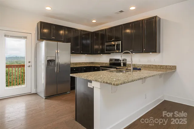 a kitchen with stainless steel appliances granite countertop a refrigerator and a sink