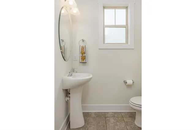 a bathroom with a sink toilet and a mirror