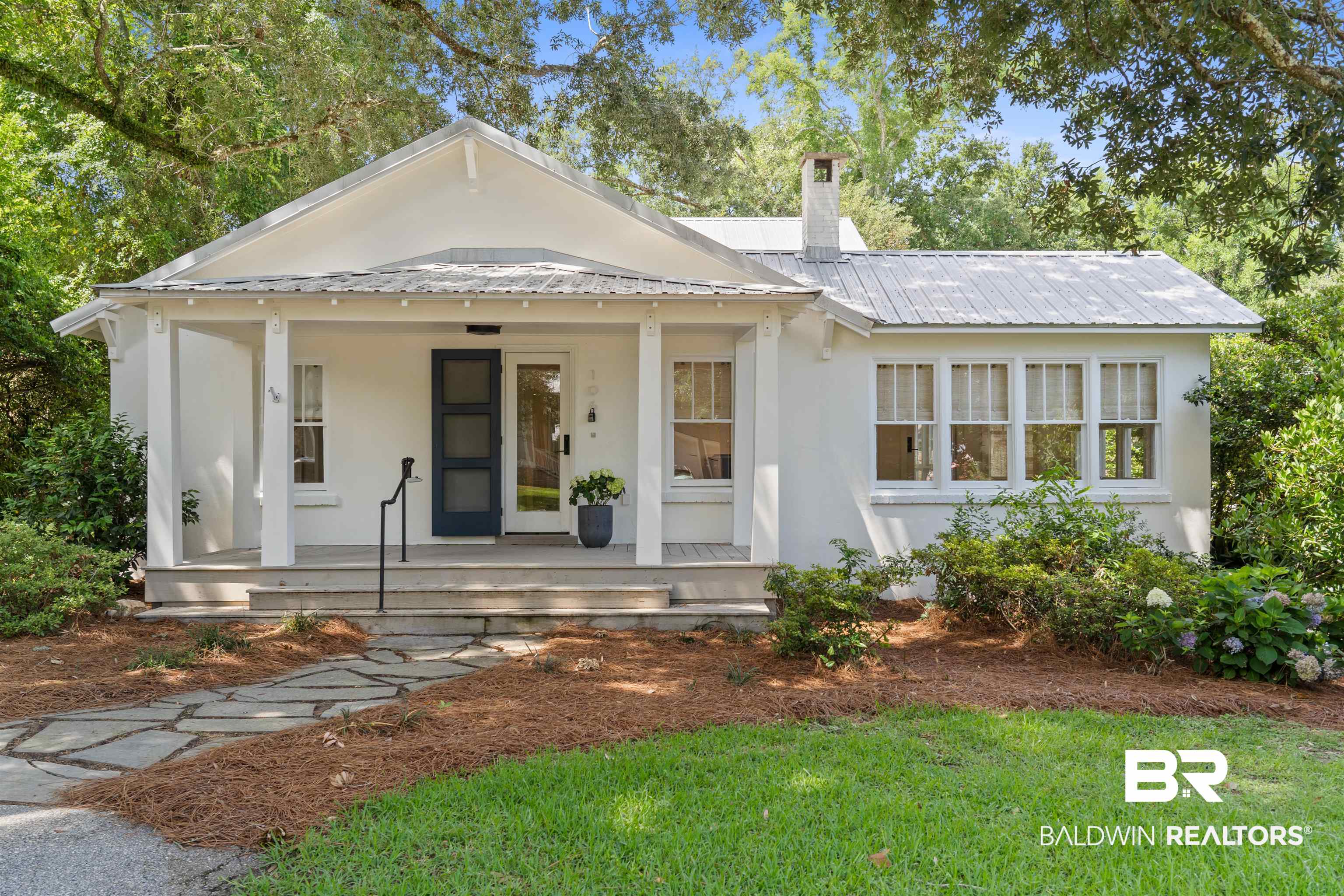 106 White Avenue Fairhope, AL 36532 - Photo 1 of 35 View of front of home with stucco siding, a porch, a chimney, a metal roof, and a front lawn