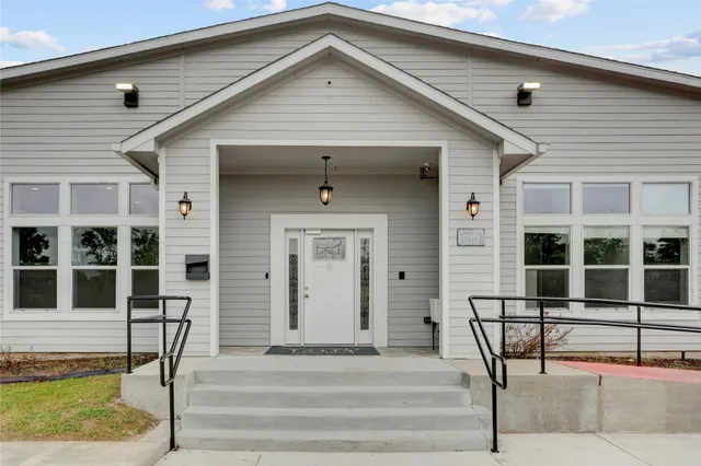 a view of house with wooden deck and furniture