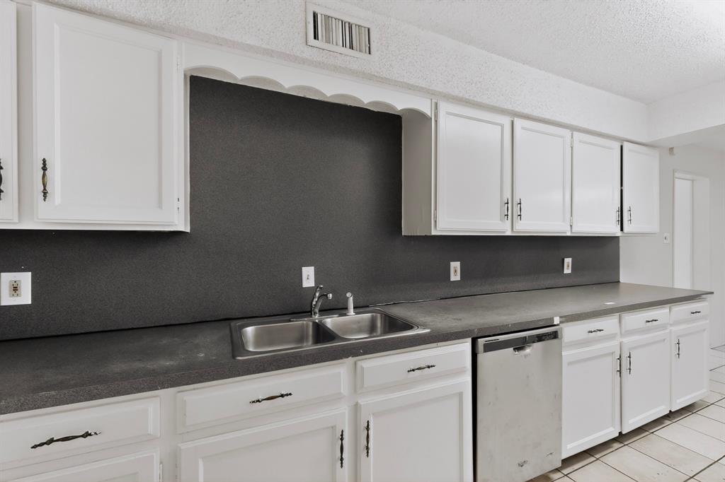 703 East Shady Grove Road Irving, TX 75060 - Photo 15 of 40 a kitchen with white cabinets and a sink