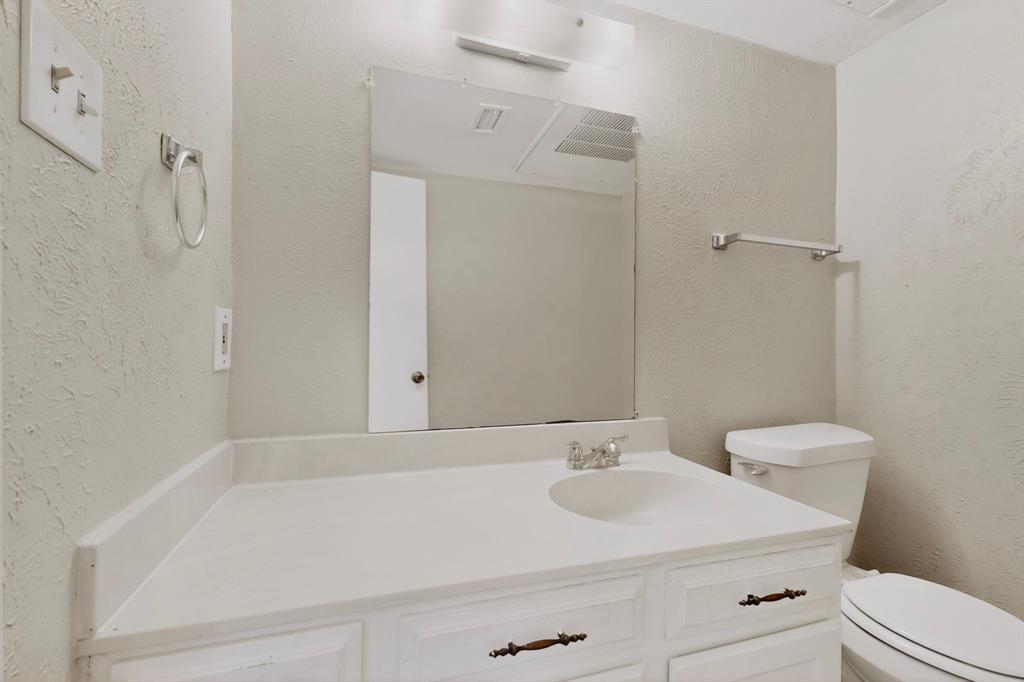 703 East Shady Grove Road Irving, TX 75060 - Photo 17 of 40 a bathroom with a sink a toilet and shower