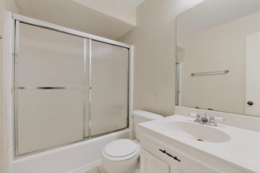 703 East Shady Grove Road Irving, TX 75060 - Photo 24 of 40 a bathroom with a sink toilet and shower