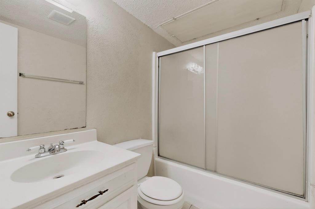 703 East Shady Grove Road Irving, TX 75060 - Photo 31 of 40 a bathroom with a sink toilet and shower