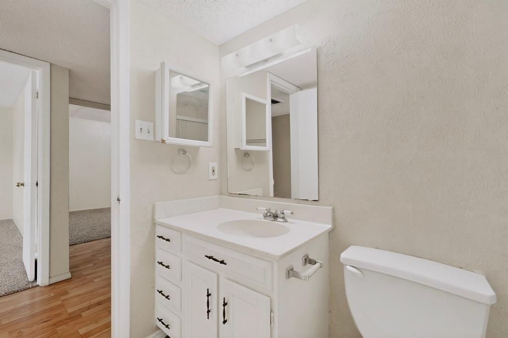 703 East Shady Grove Road Irving, TX 75060 - Photo 32 of 40 a bathroom with a toilet sink and mirror
