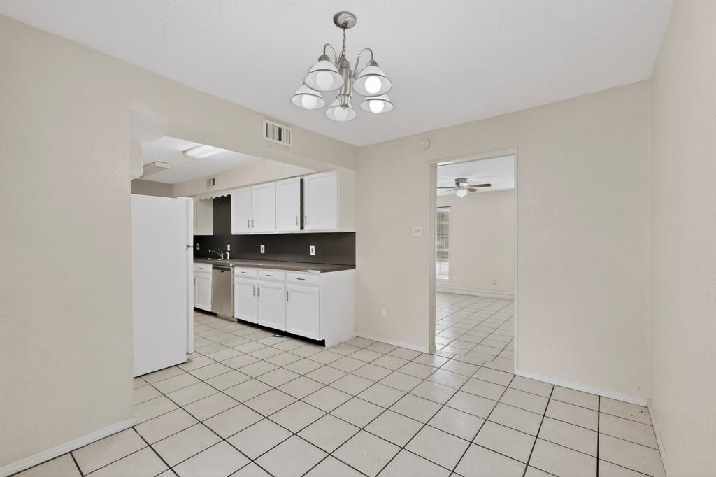 703 East Shady Grove Road Irving, TX 75060 - Photo 10 of 40 a kitchen with stainless steel appliances a white cabinet and a chandelier