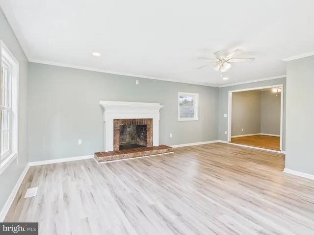 a view of empty room with wooden floor and fireplace