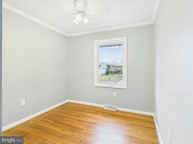 a view of empty room with wooden floor