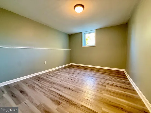 a view of room with wooden floor and white walls